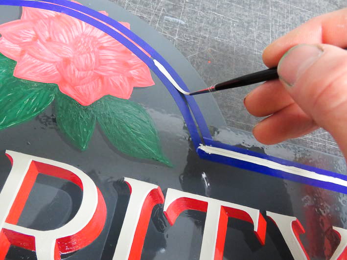 Painting inlines around the hand lettered sign