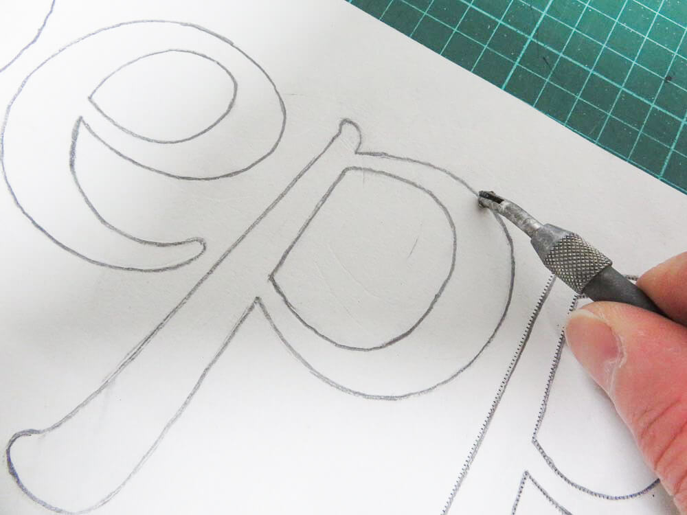 following the lettering with a pounce wheel