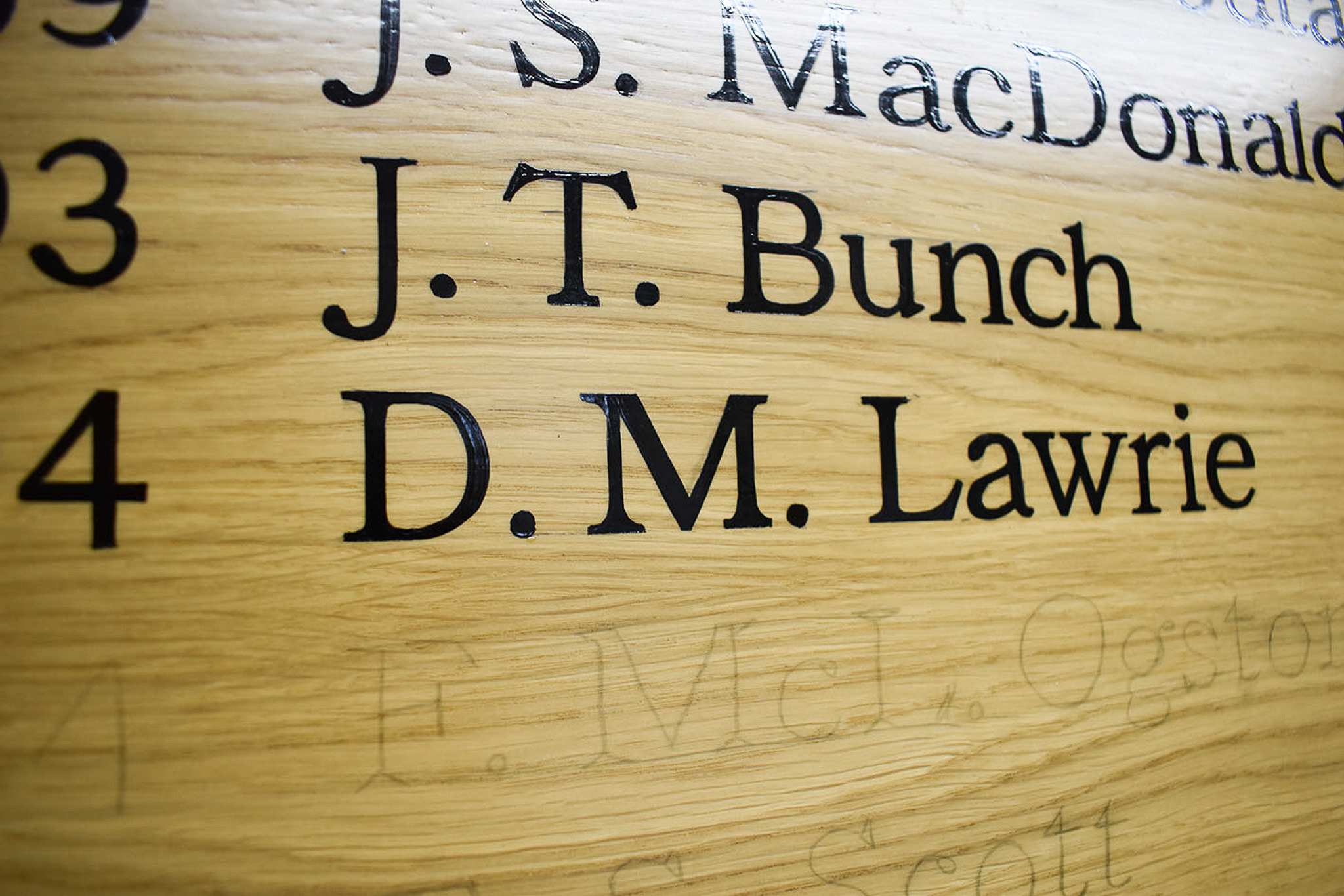 Two signwritten names on an honours board